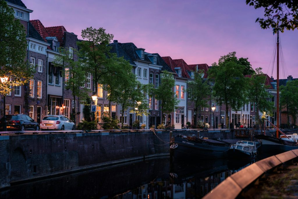 a row of houses next to a river at dusk