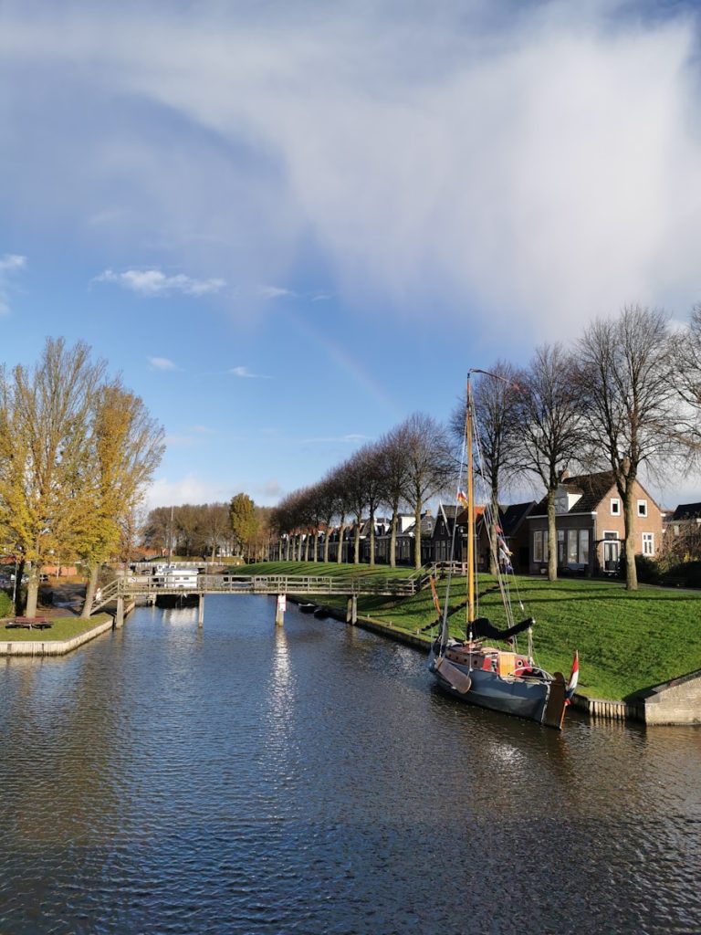 a boat on a body of water next to a row of houses