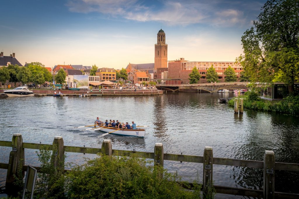 white and blue boat on water near brown concrete building dagje zwolle met kinderen during daytime