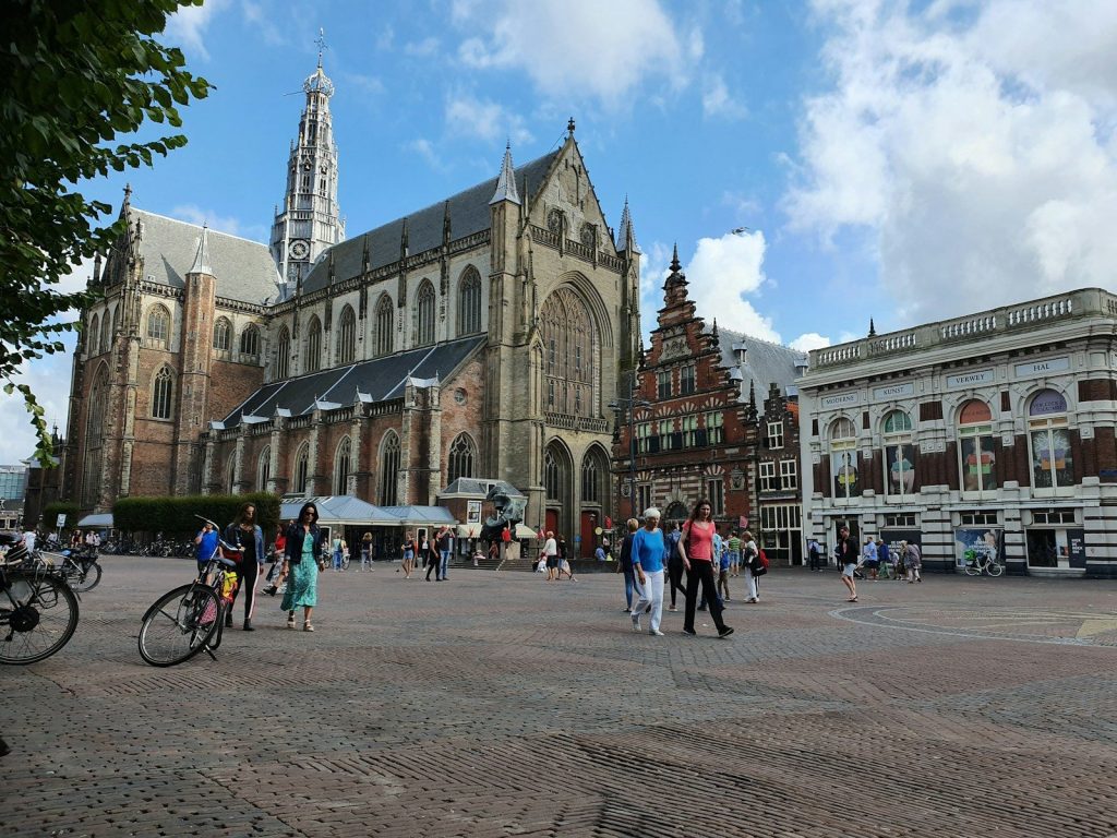 a group of people walking around a large building de leukste stedentrips in nederland in het voorjaar